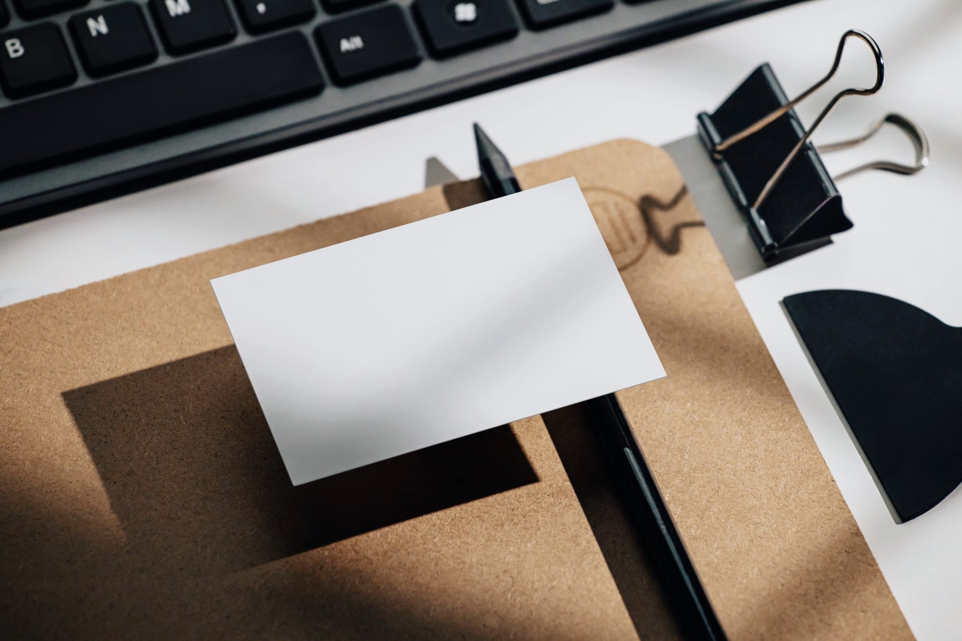 クリップボードの上に置かれた、何も書いていない白い名刺